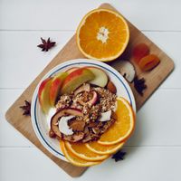 Schale mit Winter Müsli, Apfelspalten und Orangenscheiben